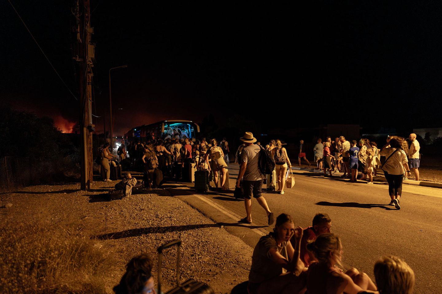 Rhodos: Menschen stehen im Dunkeln um einen Reisebus versammelt