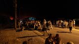 Rhodos: Menschen stehen im Dunkeln um einen Reisebus versammelt