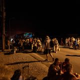 Rhodos: Menschen stehen im Dunkeln um einen Reisebus versammelt