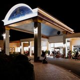 Rhodos: Menschen sitzen in der Nacht vor einem Hoteleingang