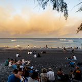 Rhodos: Am Strand sitzen Menschen mit ihrem Gepäck