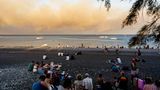 Rhodos: Am Strand sitzen Menschen mit ihrem Gepäck