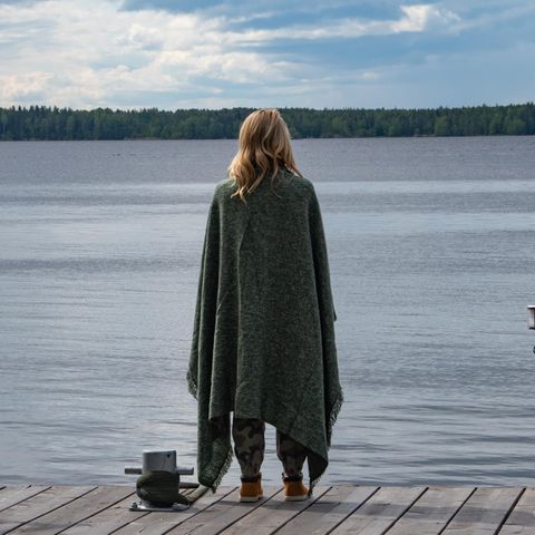 Eine Frau steht auf einem Steg am See.
