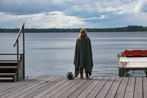 Eine Frau steht auf einem Steg am See.