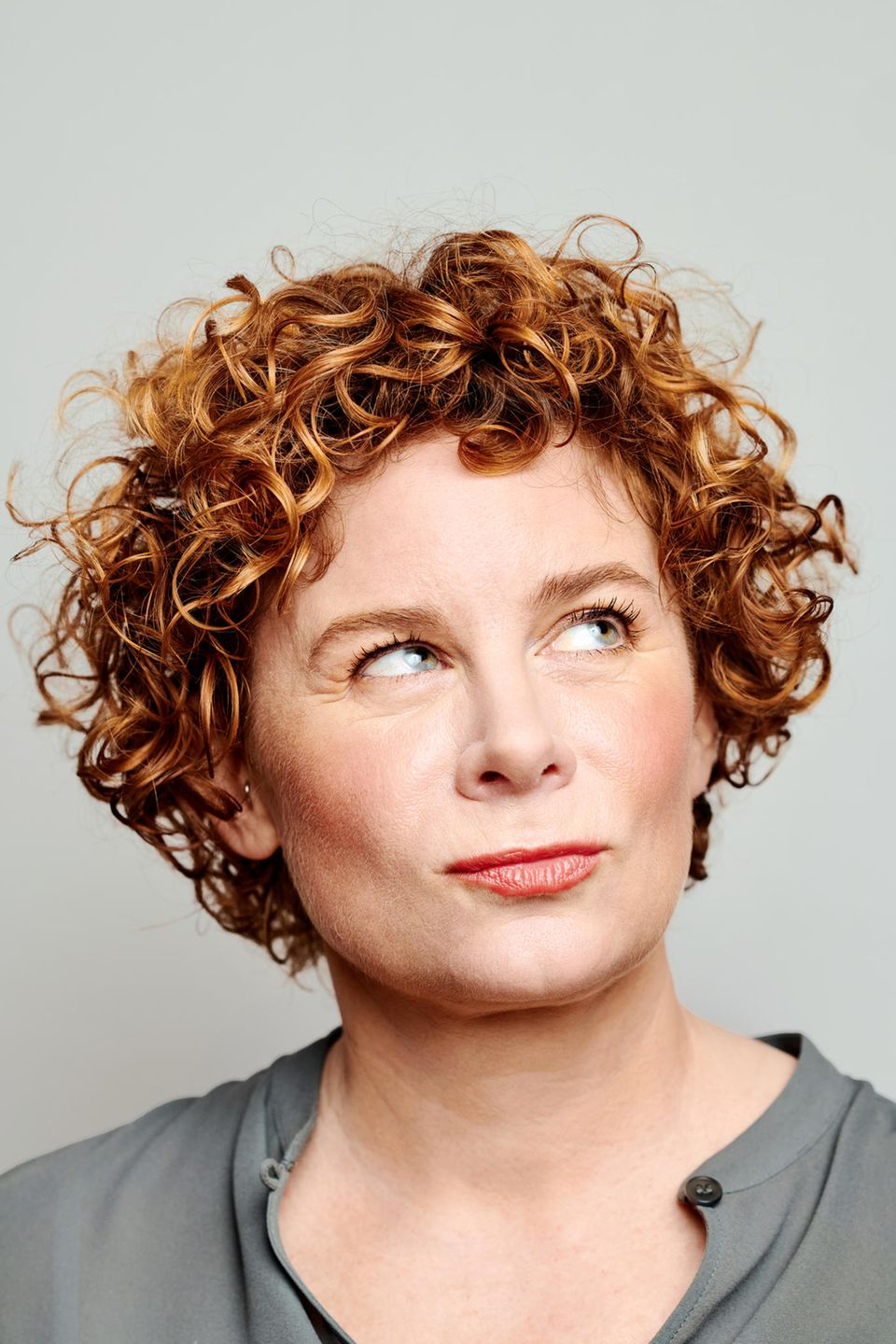 Portrait von Tina Molin, wie sie verschmitzt nach oben schaut