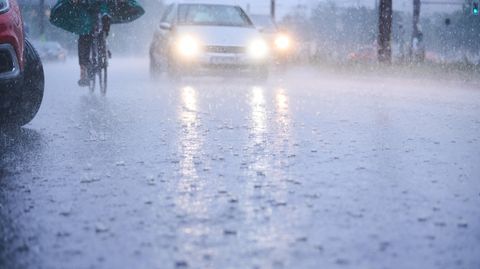 Wetter in Berlin: Berlin: Autos fahren bei starkem Regen durch tiefe Pfützen die sich auf der Fahrbahn gebildet haben