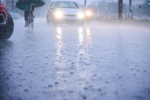 Wetter in Berlin: Berlin: Autos fahren bei starkem Regen durch tiefe Pfützen die sich auf der Fahrbahn gebildet haben