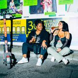 Zwei Frauen sitzen mit Bier auf der Straße