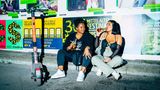 Zwei Frauen sitzen mit Bier auf der Straße