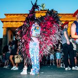 Eine Person mit Glitzer-Outfit und rosa Flügeln