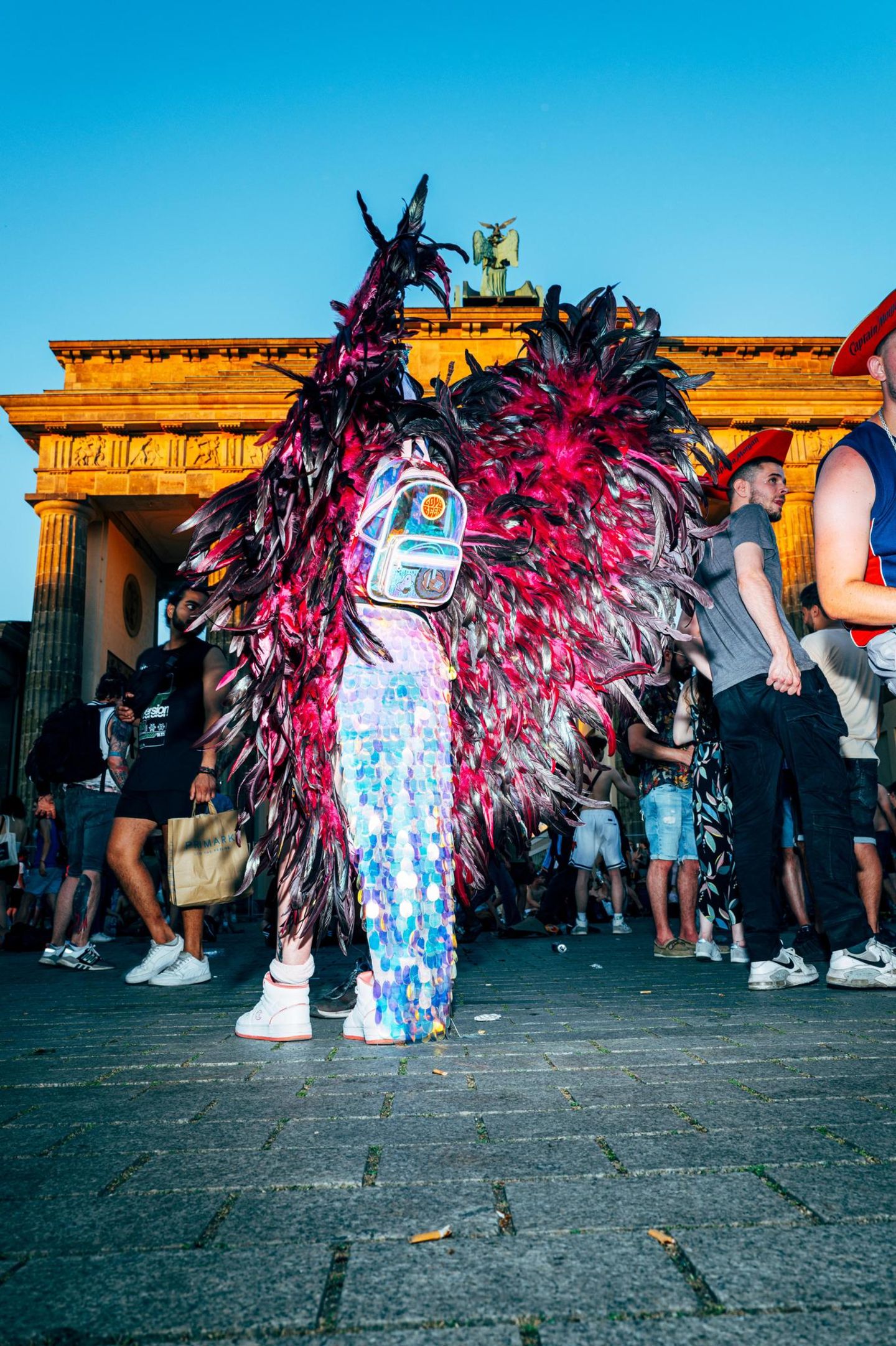 Eine Person mit Glitzer-Outfit und rosa Flügeln