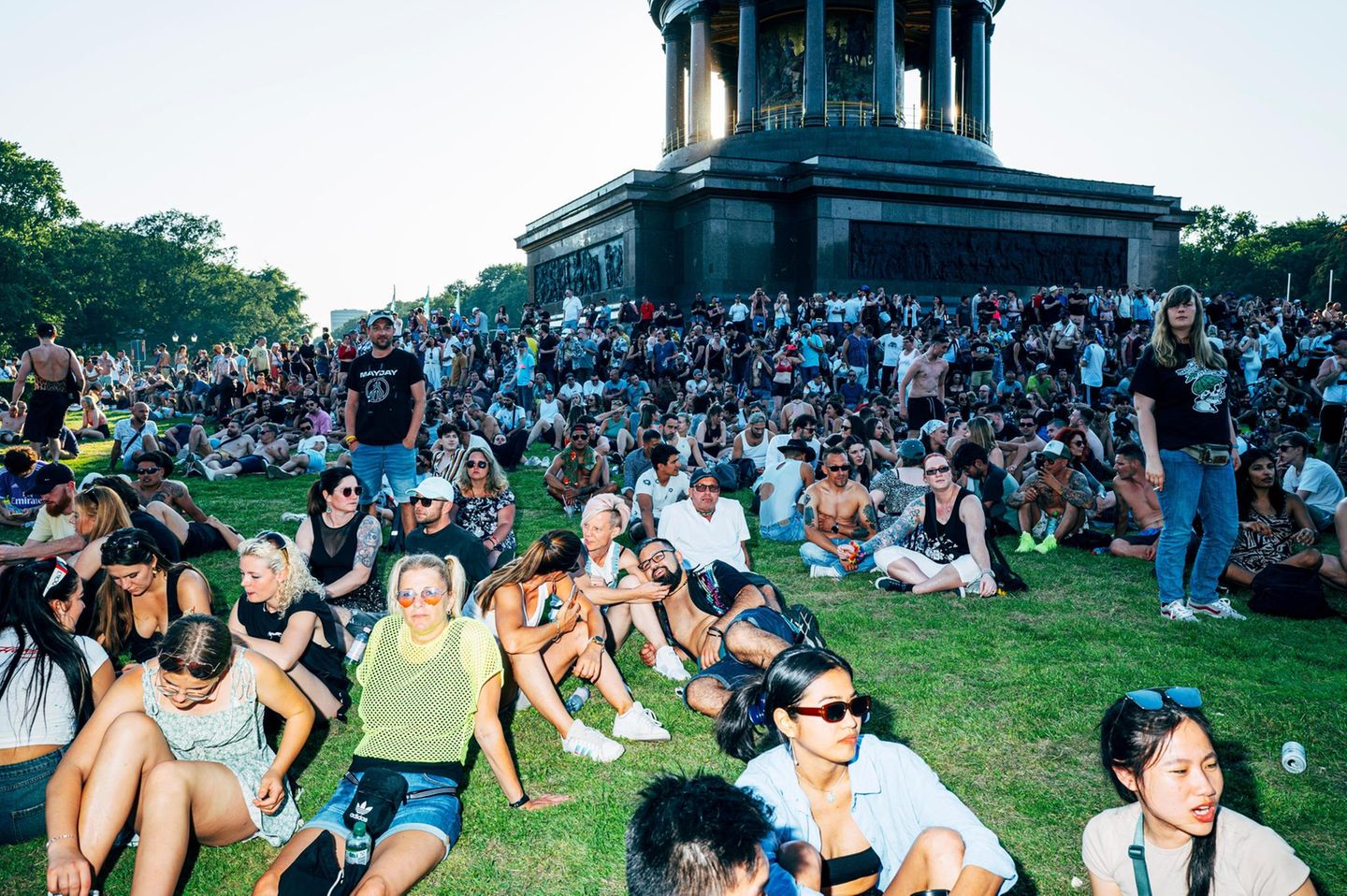 Viele Menschen sitzen auf einer Wiese