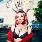 Eine junge Frau vor einem Graffity an einer Hauswand