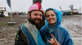 Ein Pärchen mit Regencape und bunten Helm