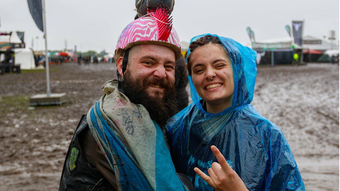 Ein Pärchen mit Regencape und bunten Helm
