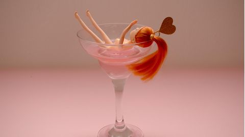 Eine Barbie liegt in einem Cocktailglas.