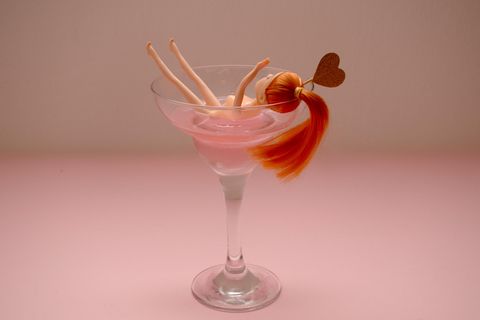 Eine Barbie liegt in einem Cocktailglas.