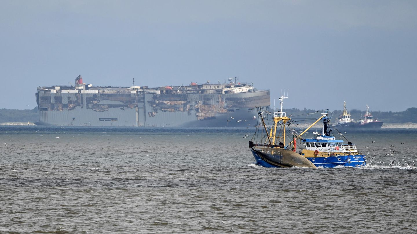 Der Autofrachter "Fremantle Highway" (Hintergrund) wird von zwei Booten auf der Außenems vor Borkum geschleppt