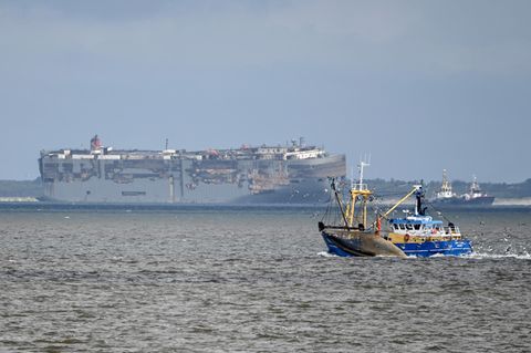 Der Autofrachter "Fremantle Highway" (Hintergrund) wird von zwei Booten auf der Außenems vor Borkum geschleppt