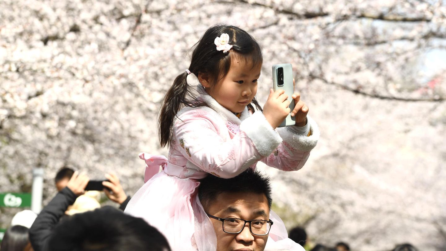 Wer noch keine 18 Jahre alt ist, soll in China ab dem 2. September zwischen 22.00 Uhr und 6.00 Uhr vom mobilen Internet abgeschnitten sein Mädchen mit Smartphone in der Hand