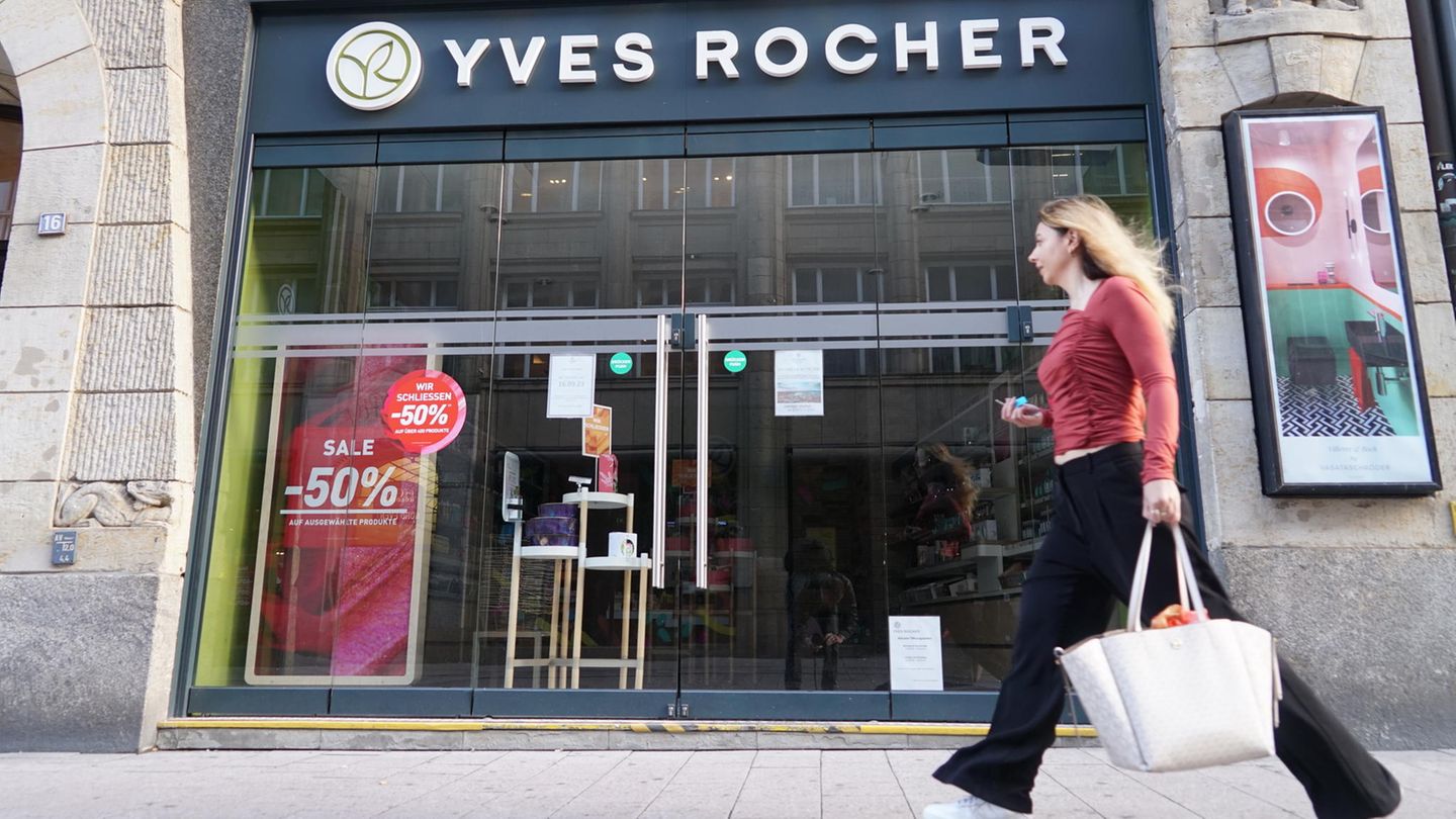 Eine junge Frau läuft an einer Yves Rocher-Filiale in Hamburg entlang