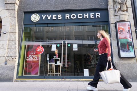 Eine junge Frau läuft an einer Yves Rocher-Filiale in Hamburg entlang