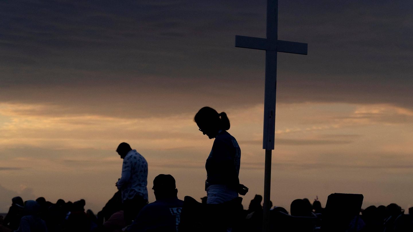 Großes Holzkreuz vor einem Sonnenuntergangshimmel