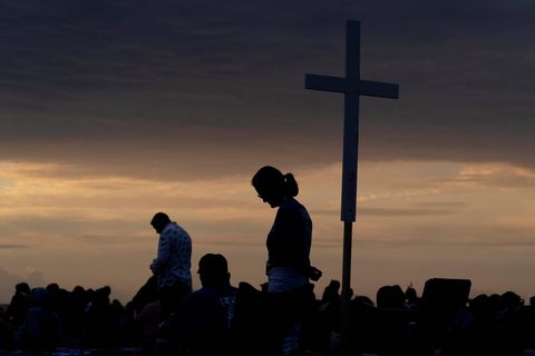 Großes Holzkreuz vor einem Sonnenuntergangshimmel