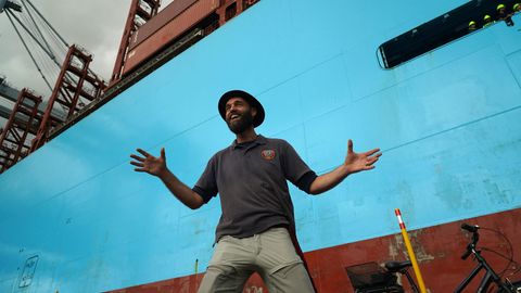 Der Däne Torbjørn C. Pedersen vor einem Containerschiff bei der Rückkehr von seiner Weltreise