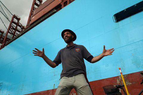 Der Däne Torbjørn C. Pedersen vor einem Containerschiff bei der Rückkehr von seiner Weltreise