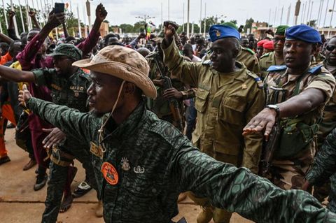 Oberst-Major Amadou Adramane (2.v.r.) wird bei seiner Ankunft im General-Seyni-Kountché-Stadion in der Hauptstadt Niamey von Anhängern begrüßt. Berichten zufolge versammelten sich am Sonntag hier Zehntausende Menschen, um gegen die Ecowas-Sanktionen zu protestieren
