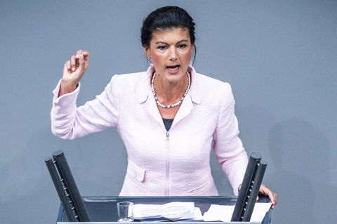 Sahra Wagenknecht steht am Rednerpult des Deutschen Bundestages und hält beim Reden die rechte Hand hoch