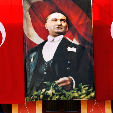 Ein Bild von Mustafa Kemal Atatürk neben zwei Flaggen der Türkei