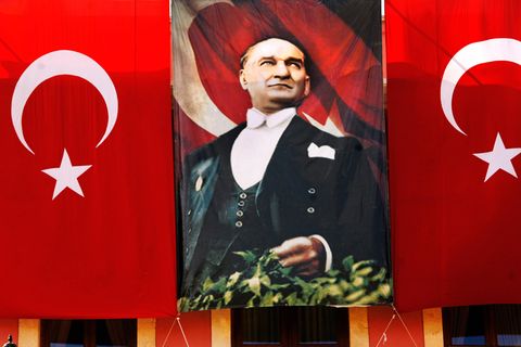 Ein Bild von Mustafa Kemal Atatürk neben zwei Flaggen der Türkei