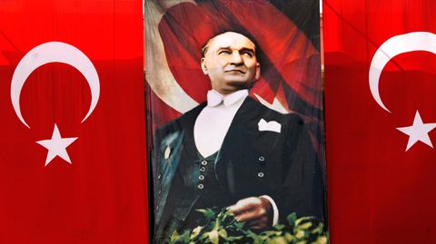 Ein Bild von Mustafa Kemal Atatürk neben zwei Flaggen der Türkei