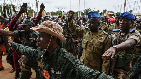 Oberst-Major Amadou Adramane (2.v.r.) wird bei seiner Ankunft im General-Seyni-Kountché-Stadion in der Hauptstadt Niamey von Anhängern begrüßt. Berichten zufolge versammelten sich am Sonntag hier Zehntausende Menschen, um gegen die Ecowas-Sanktionen zu protestieren