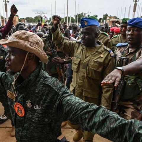 Oberst-Major Amadou Adramane (2.v.r.) wird bei seiner Ankunft im General-Seyni-Kountché-Stadion in der Hauptstadt Niamey von Anhängern begrüßt. Berichten zufolge versammelten sich am Sonntag hier Zehntausende Menschen, um gegen die Ecowas-Sanktionen zu protestieren