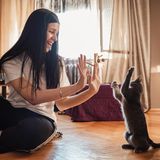 Frau spielt mit Katze