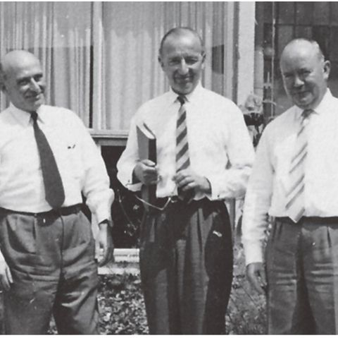 Black and white picture: three men stand side by side