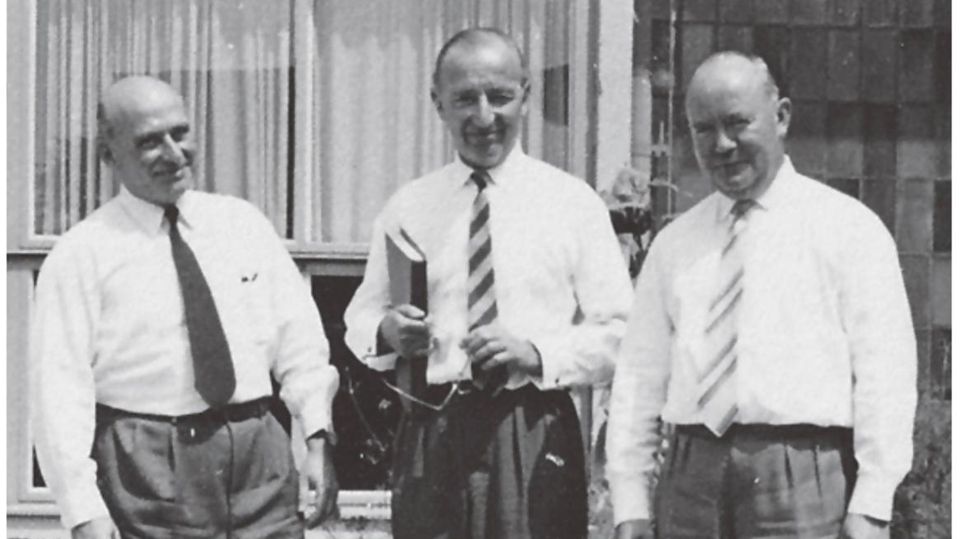 Schwarz-weiß Bild: Drei Männer stehen nebeneinander