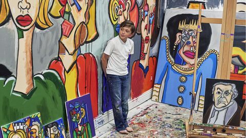 Der Zehnjährige Andres Valencia steht in einem Raum mit vielen seiner Bilder