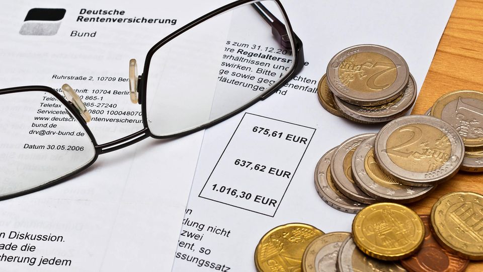 Rentenbescheid der Deutschen Rentenversicherung, darauf eine Lesebrille und einige Euro-Münzen