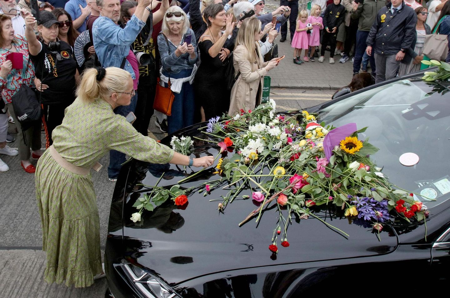Sinéad O'Connor war im Juli dieses Jahres aus bislang ungeklärter Ursache im Alter von 56 Jahren in London verstorben. Bestattet wird sie in ihrer Heimat Irland, in Bray hat die Künstlerin zeitweise gelebt. Fans legen Blumen auf das Trauerfahrzeug, in dem O'Connor zu ihrer letzten Ruhestätte gefahren wird.