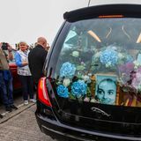 Der Kofferraum ist ausgeschmückt mit Blumen und Gestecken. Dazu erinnert ein Foto an die irische Sängerin, die 1990 mit dem Song "Nothing Compares 2 U" berühmt wurde. Das Stück war fünf Jahre zuvor von Prince komponiert worden, die von ihm protegierte Band The Family hatte es veröffentlicht. Erst Sinéad O'Connor verhalf dem Song zu Weltruhm - und der Song umgekehrt ihr. 