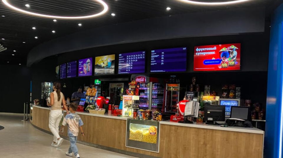 Menschen gehen in ein Kino in einem Einkaufszentrum in Moskau