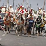 Vergangenheit trifft Gegenwart: Traditionell gekleidete Reiter auf dem Weg zur Fantasia