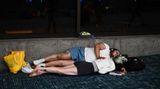 Ein junges Paar versucht sich am Terminal am Flughafen auf Hawaii auszuruhen