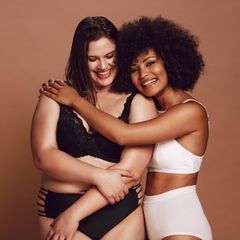 Zwei Frauen umarmen sich in Dessous