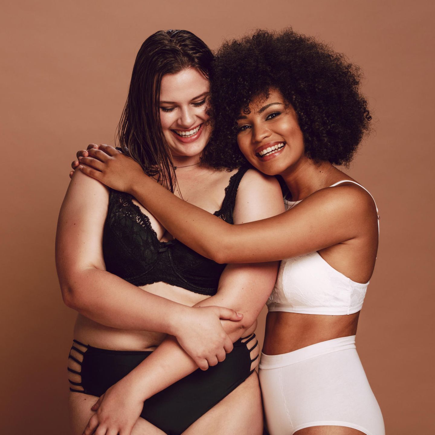 Zwei Frauen umarmen sich in Dessous