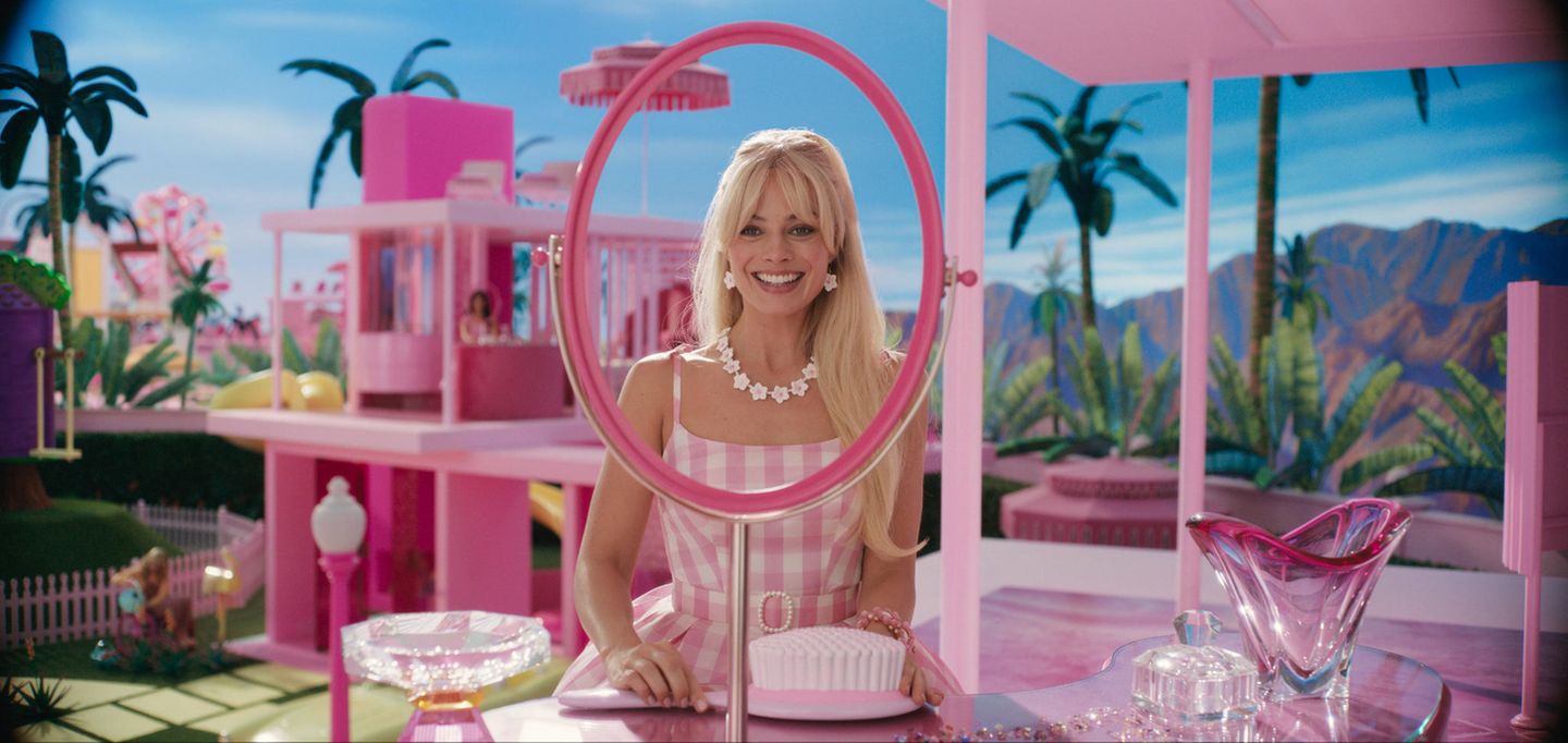 Das ikonische "Barbie"-Bild von Margot Robbie im karierten Kleid mit Blütenkette und -ohrringen ging bereits vor Kinostart um die Welt.